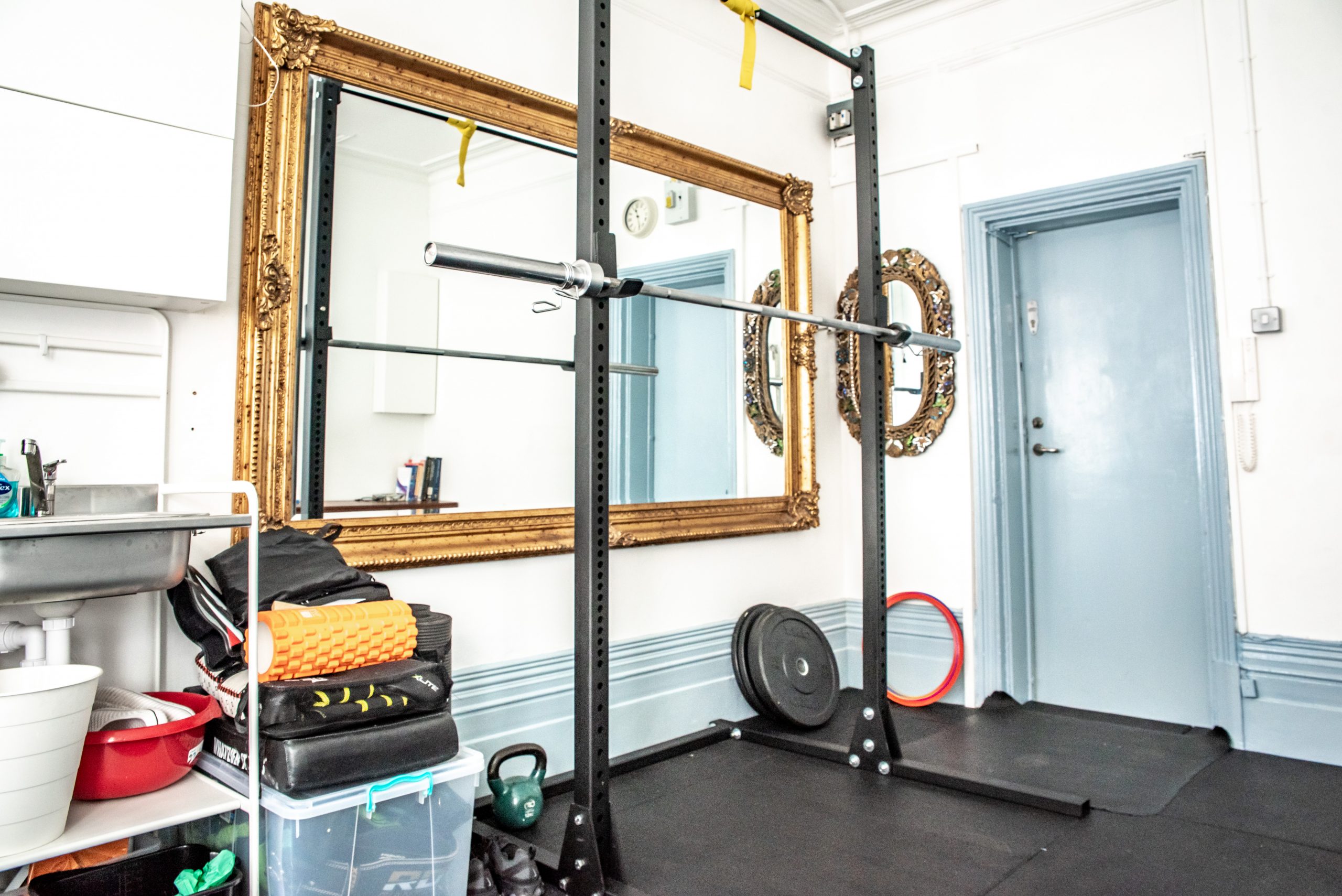 The studio rack beside the antique gold mirror