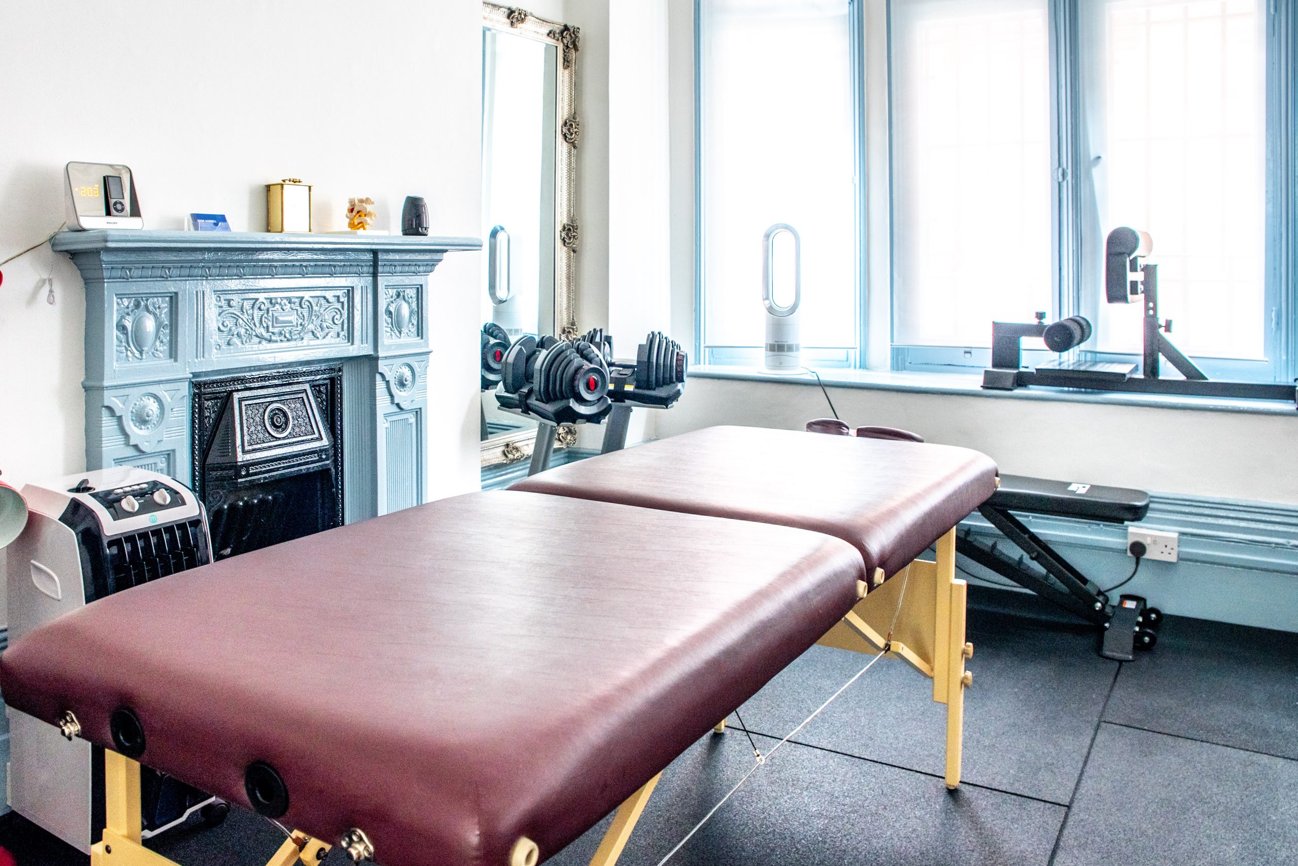 The treatment room with its Victorian fireplace and antique mirror